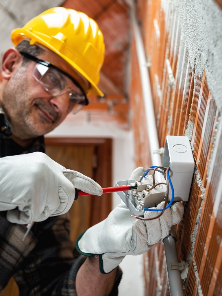 Electrician at work in an electrical system of a construction site. Construction industry.